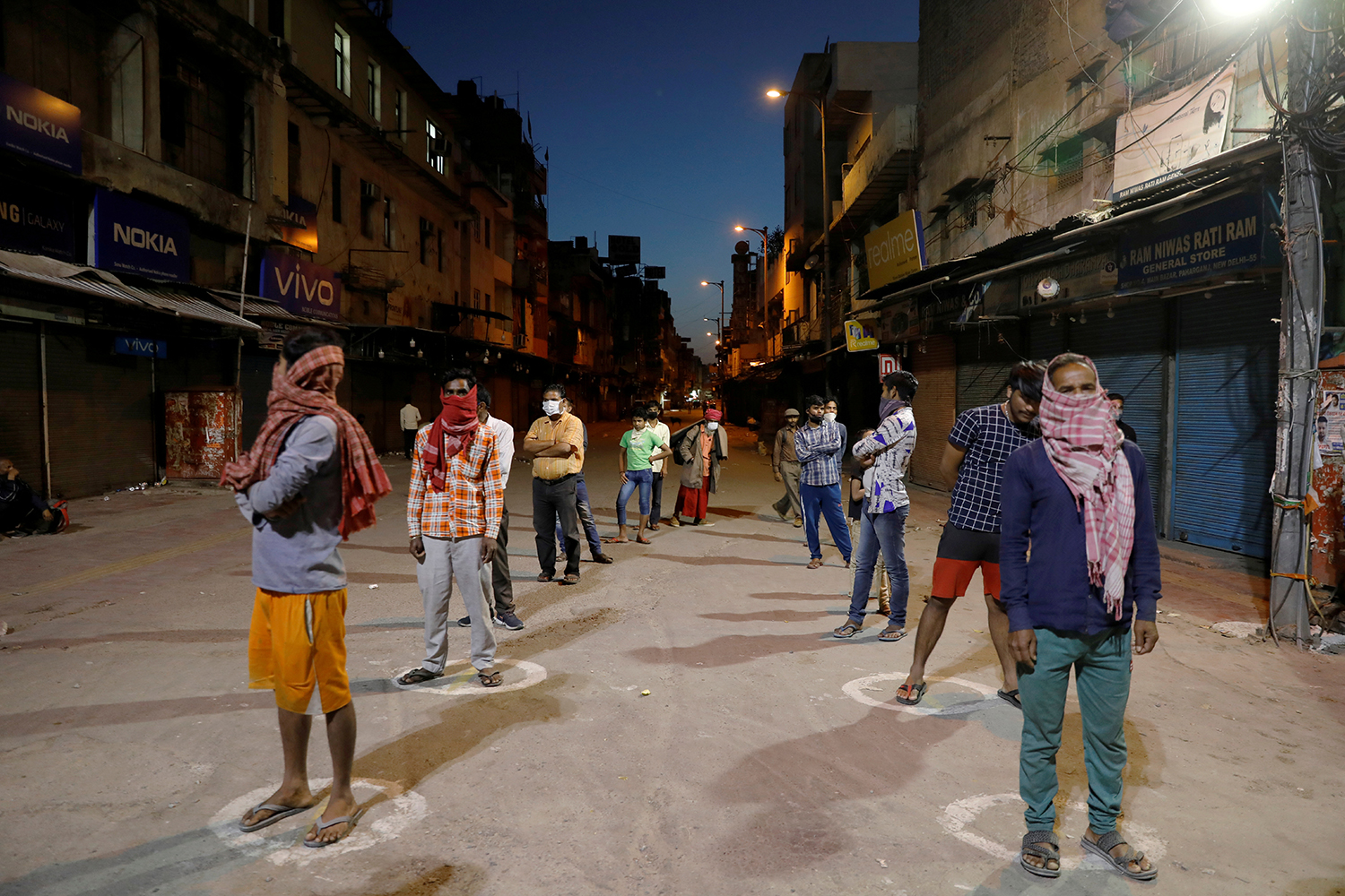 People stand apart in a line to receive free food being distributed on a street during a 21-day nationwide lockdown to limit the spreading of coronavirus disease (COVID-19), in New Delhi